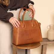 Styled Fit Perspective of Marsala Full-Grain Leather Handbag för Dam on Model - Natural Daylight Drape