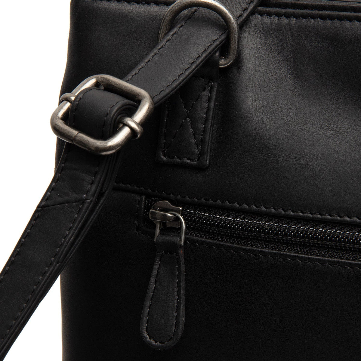 
Solid Antique Brass Hardware & Heavy-Duty Dual Zipper Detail on Raynor Tygkasse i läder